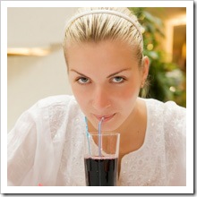 Beautiful blond girl drinks grape juice in a restaurant